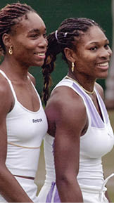 WIMBLEDON, UNITED KINGDOM - JULY 4: US sisters Venus (L) and Serena Williams smile after winning their Women's Doubles 3rd round match at the Wimbledon 2000 tennis tournament against Romanian Irina Spirlea and her Dutch partner Carroline Vis 04 July 2000. The Williams sisters won the match 6-3, 6-2.     (ELECTRONIC IMAGE)  (Photo credit should read MARTYN HAYHOW/AFP via Getty Images)