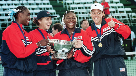 PALO ALTO, UNITED STATES: Lindsay Davenport (R) gives a thumbs up as teammates, (L-R) Venus Williams, Monica Seles, and Serena Williams of the USA pose after receiving the Fed Cup trophy during the Federation Cup 19 September, 1999, at Stanford University in Palo Alto, California. The US defeated Russia.  AFP PHOTO/John G. MABANGLO (Photo credit should read JOHN G. MABANGLO/AFP via Getty Images)