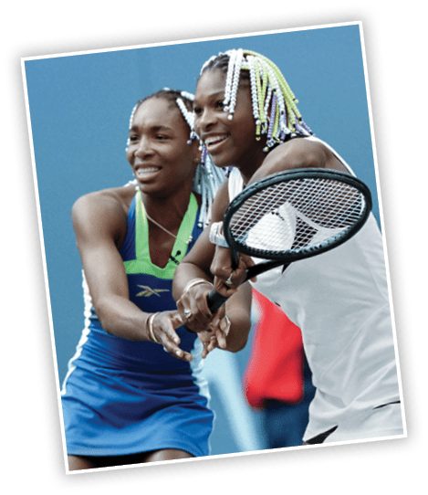 NEW YORK, UNITED STATES: Sisters Venus (L) and Serena (R) Williams share a racket during an exhibition match 29 August at the US Tennis Center in Flushing Meadows, New York, prior to the start of the US Open 31 August. The Arthur Ashe Stadium Show, in honor of the late tennis star, featured tennis players and entertainment personalities  and helped raise money for charities. AFP PHOTO Stan HONDA (Photo credit should read STAN HONDA/AFP via Getty Images)